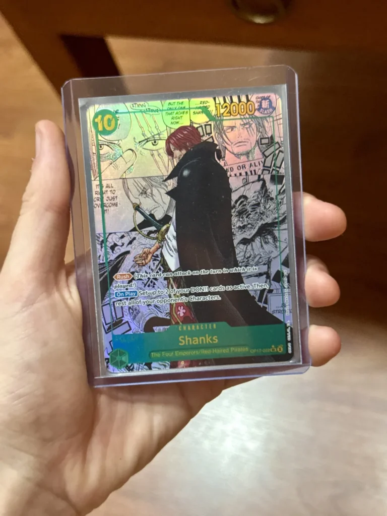 Carta manga de Shanks OP17-022 de One Piece TCG en versión inglesa, dentro de un toploader